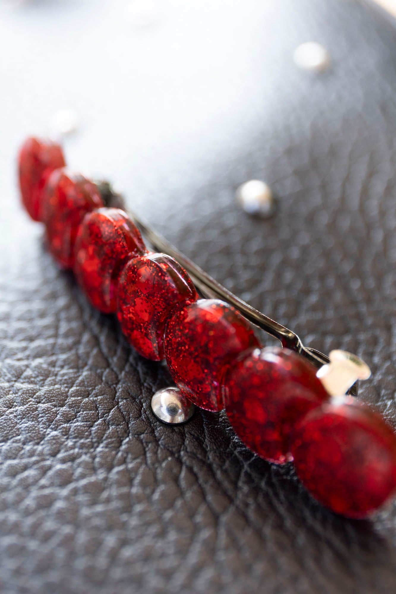 Barrette rouge paillettée en résine époxy.