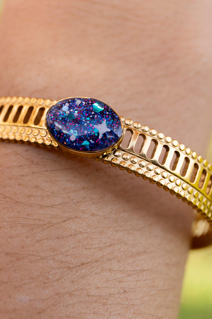 Bracelet jonc réglable pailletté. Noir, doré, holograohique. Automne. Atelier Rézane. Résine époxy. Fait main. Pays basque. Acier inoxydable.
Motifs galaxie peints à la main.