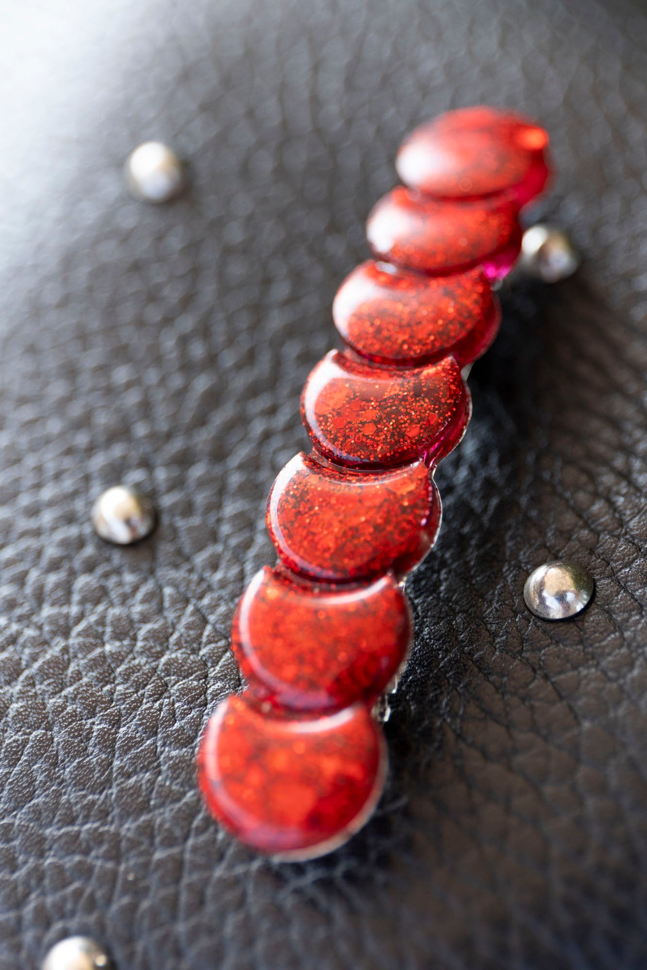 Barrette rouge paillettée en résine époxy.