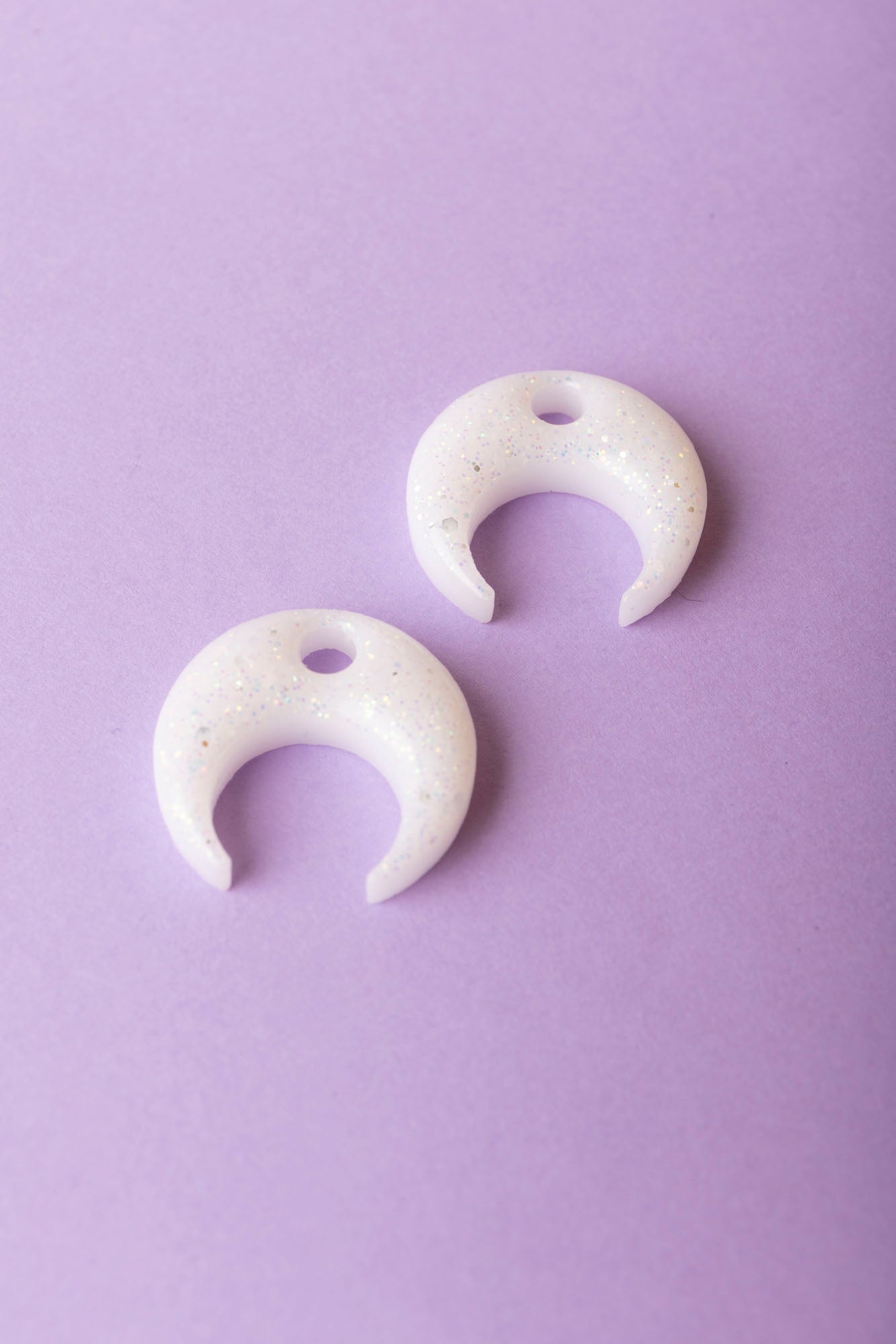 Pampille en forme de demi-lune en résine époxy, fabriquée à la main. 